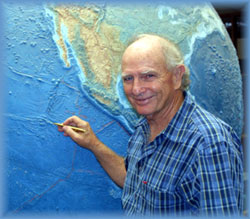 [image: Dr. Peter Glynn pointing at Clipperton Atoll on a globe]